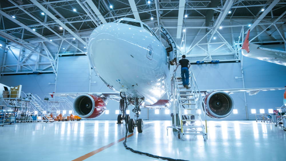 Aircraft and mechanic in MRO hangar