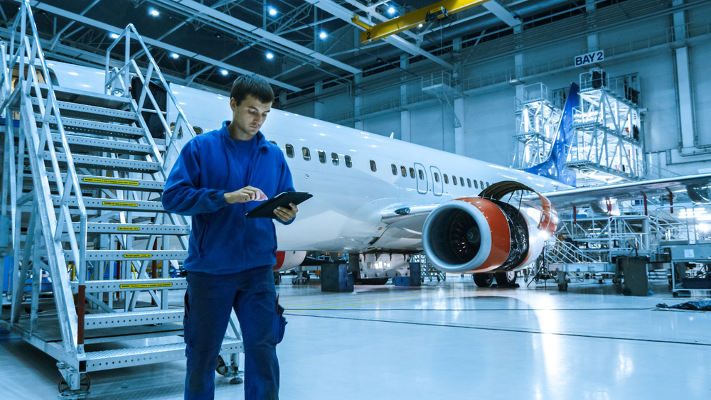 Mechanic checking tablet at MRO hangar