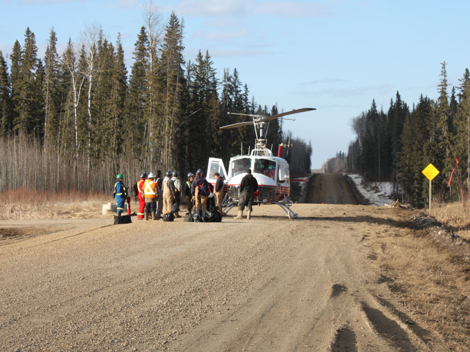 Delta Helicopters Bell 204B helicopter picks up forestry crew from dirt road in Northern Alberta