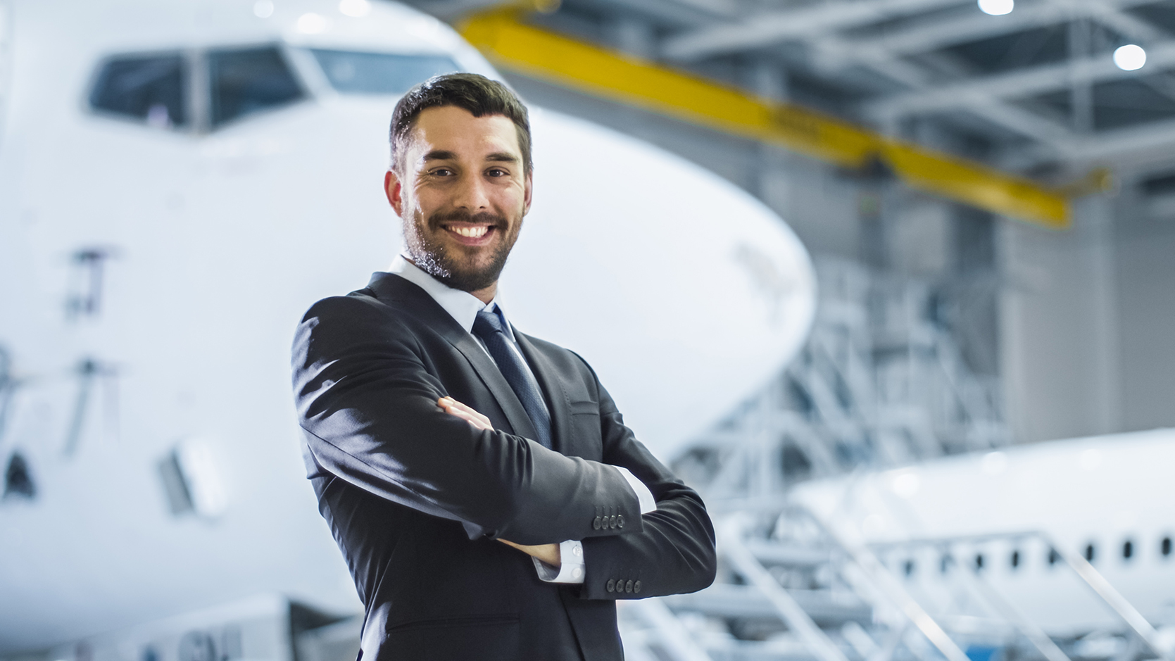 Business Owner stands next to aircraft in hangar