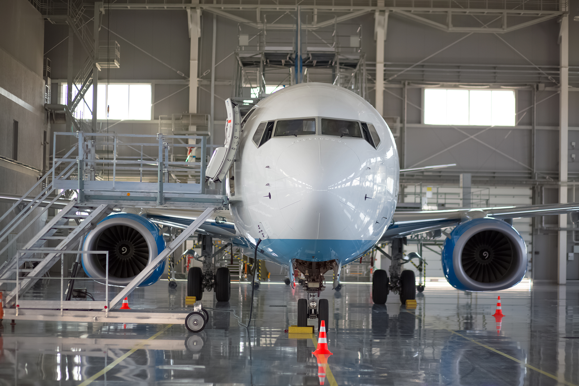 A fixed-wing aircraft sits in the hangar at a maintenance facility