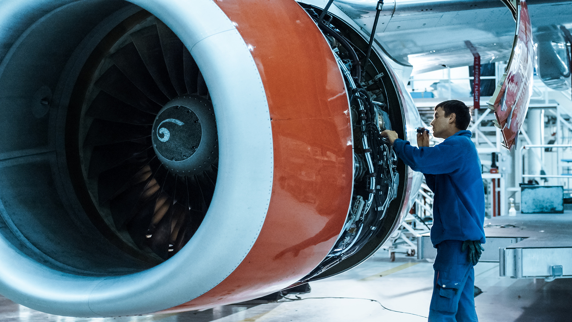 aircraft mechanic inspects engine at maintenance facility