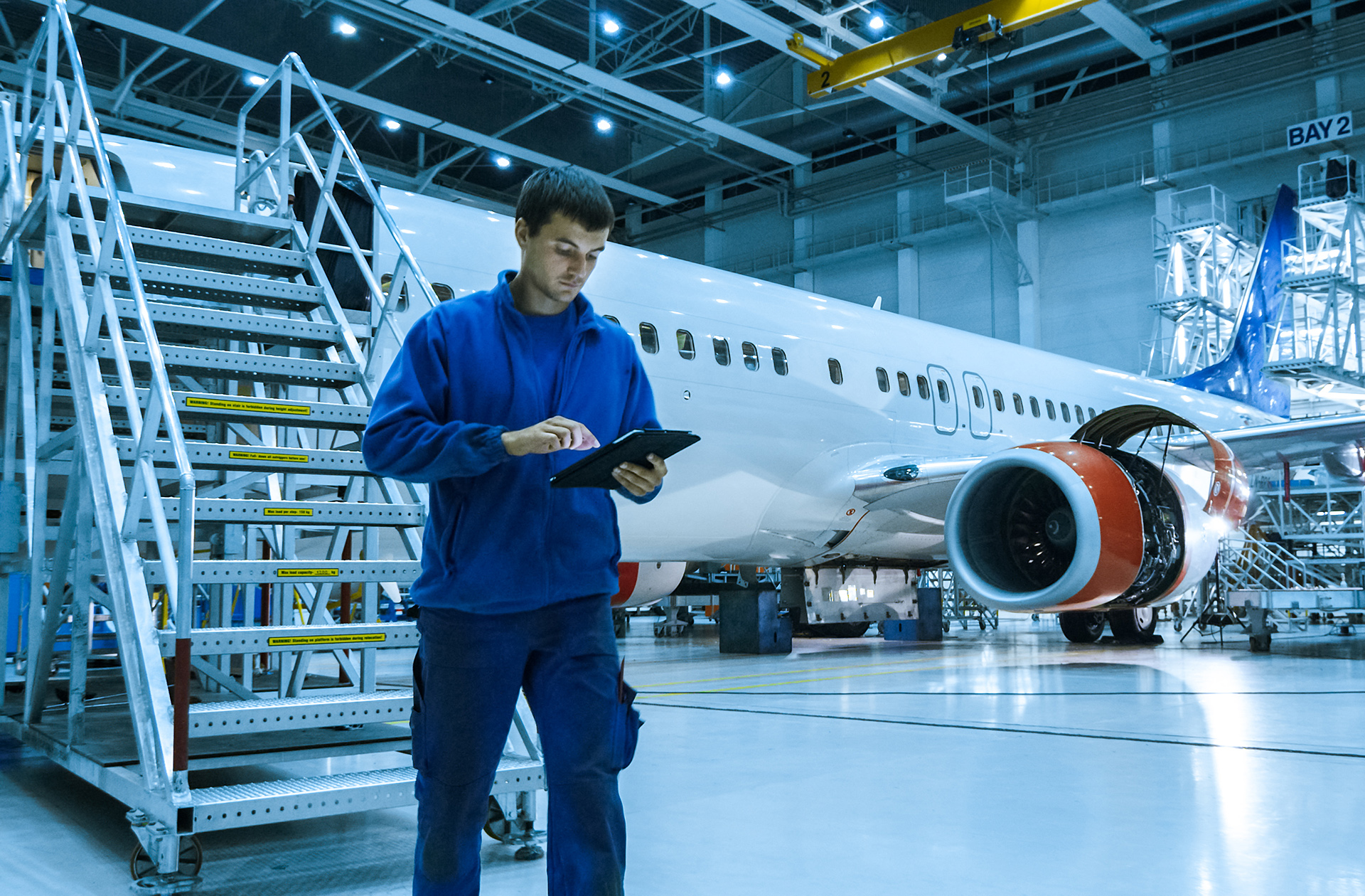 An AME uses a tablet next to an aircraft