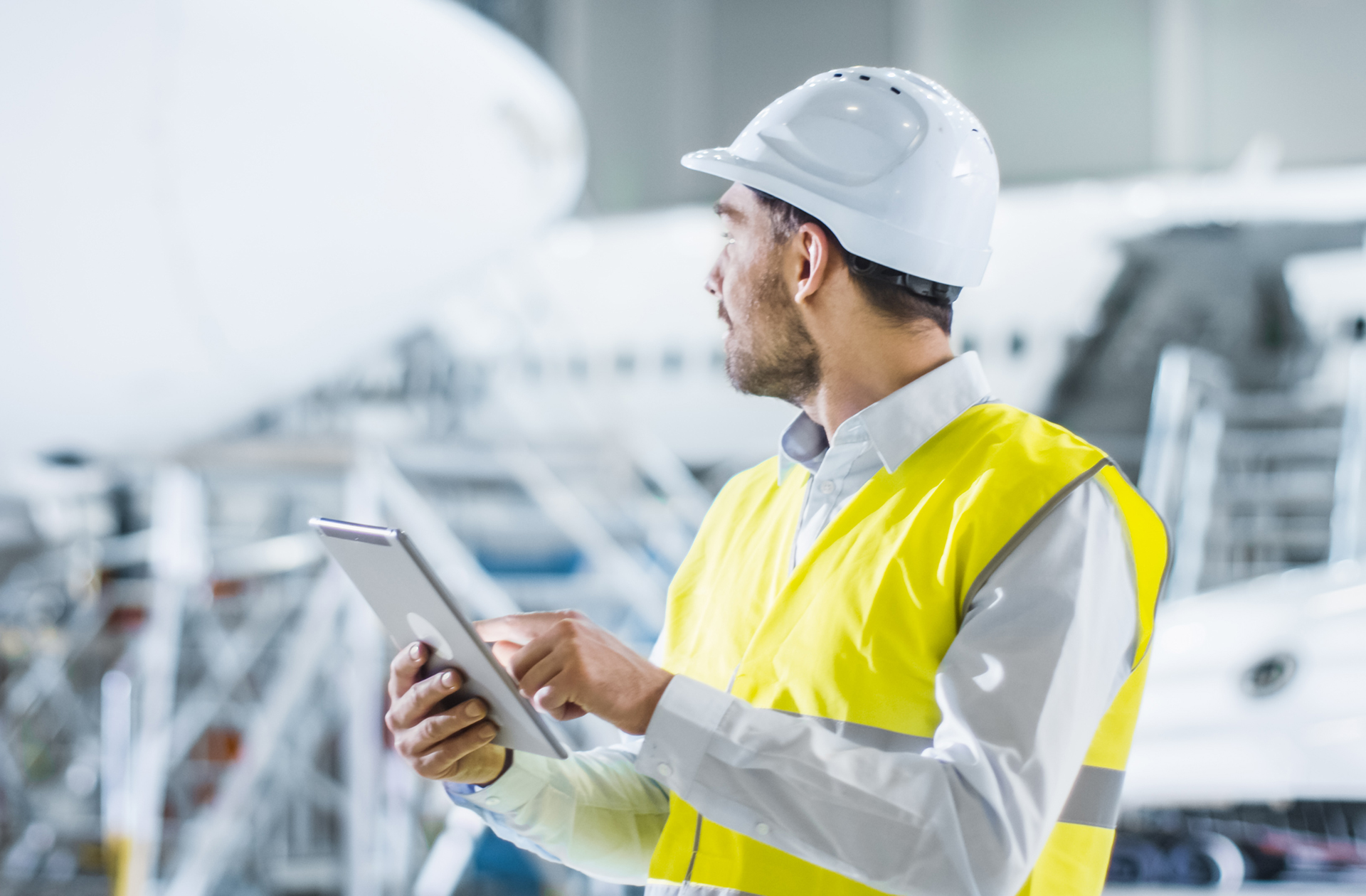 A DOM reviews information on a tablet next to multiple aircraft