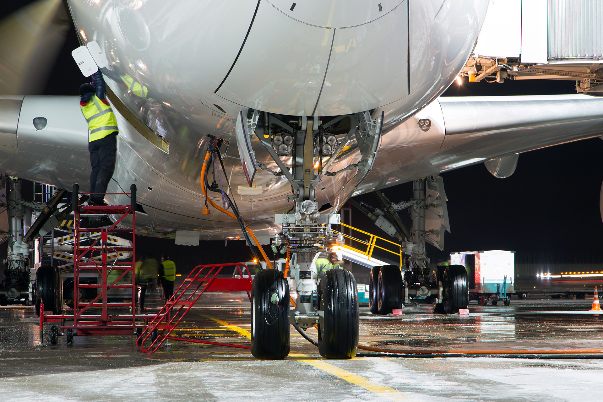 Staff perform maintenance on an aircraft at night